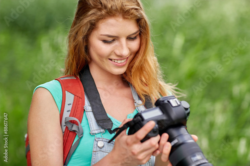 happy woman with backpack and camera outdoors