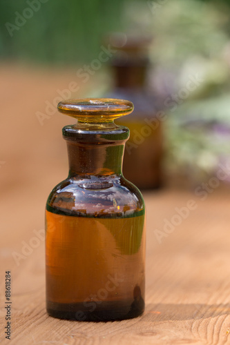 essential oil in little bottle and medical flowers herbs