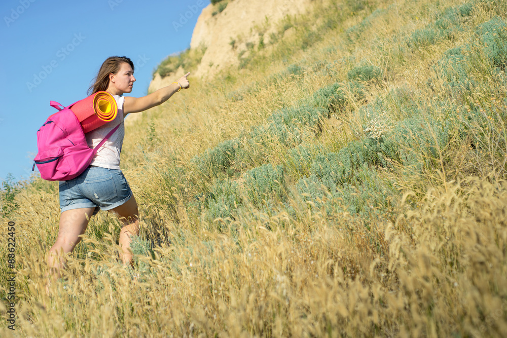 a woman with a backpack indicate the way up