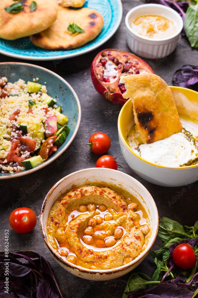 Table served with middle eastern vegetarian dishes. Hummus, tahi Table served with middle eastern vegetarian dishes. Hummus, tahi