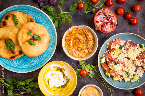 Table served with middle eastern vegetarian dishes. Hummus, tahi