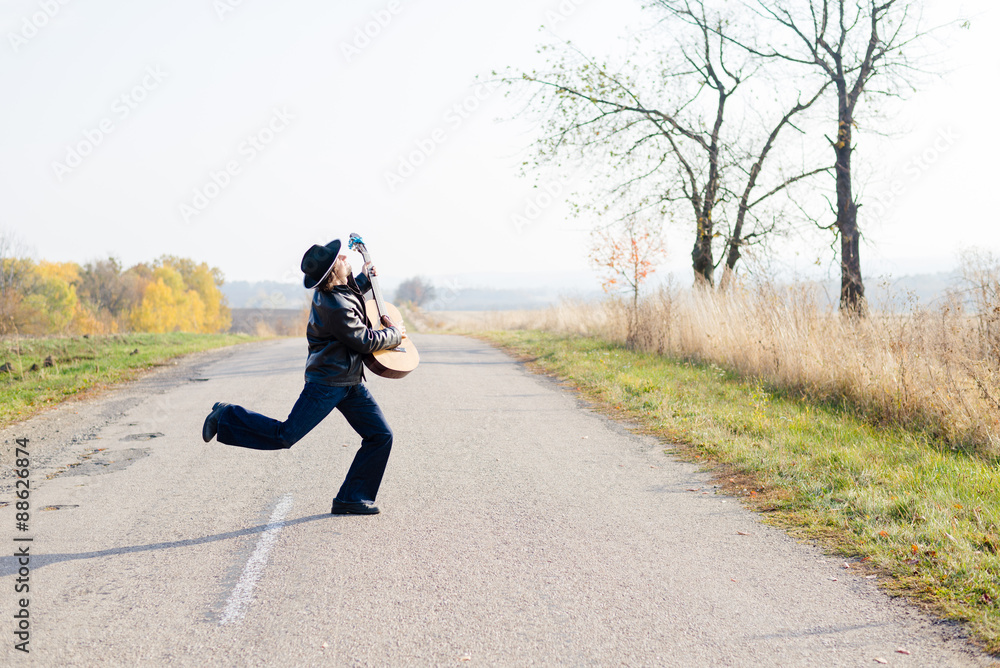 Obraz premium Picture of excited giutarist playing guitar crazy crossing road