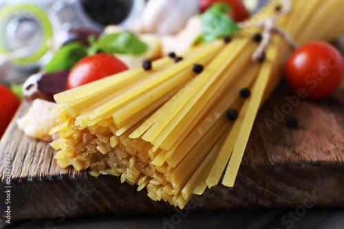 Raw pasta with cheese and vegetables on table close up