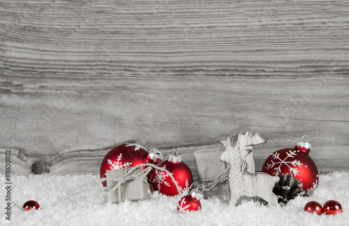 Weihnachtsgutschein oder Weihnachtskarte mit Holz Hintergrund und Dekoration in rot, weiß, grau.