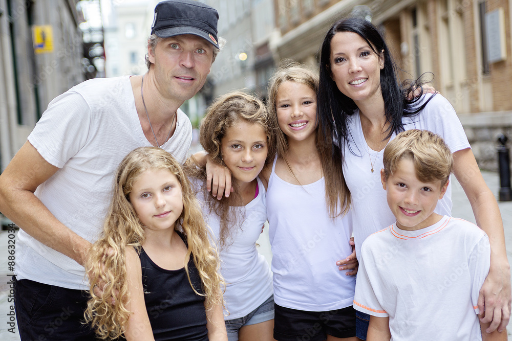 Summer family portrait of parents and kids outside in urban style Summer family portrait of parents and kids outside in urban style