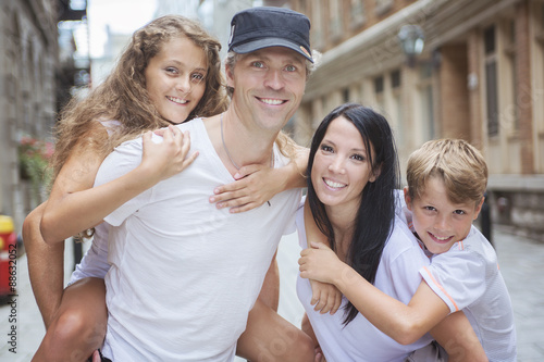 Summer family portrait of parents and kids outside in urban style