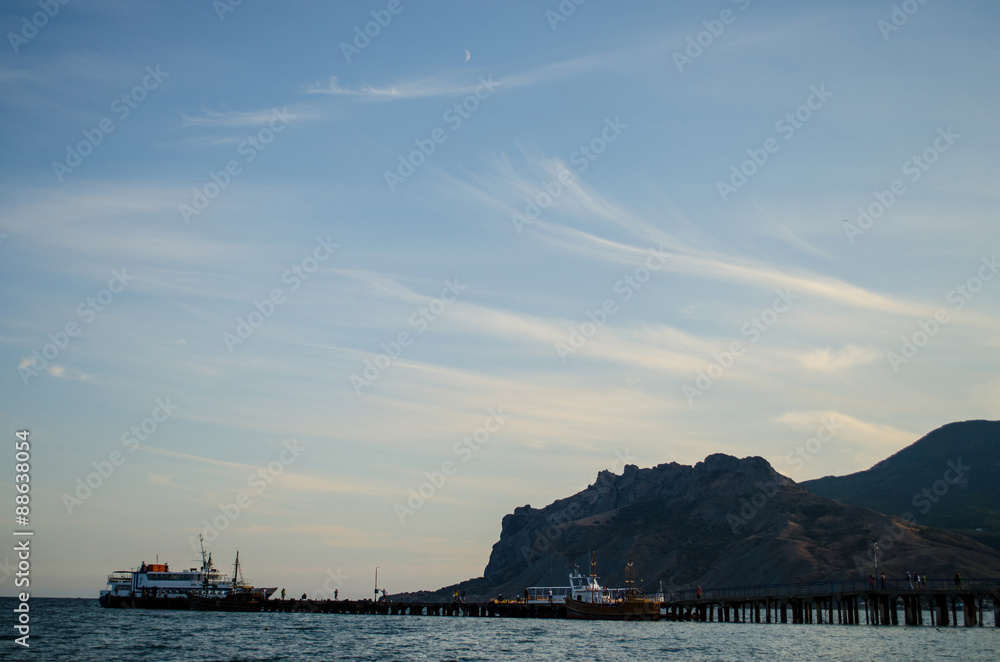 High mountains and a wooden pier on the sea coast