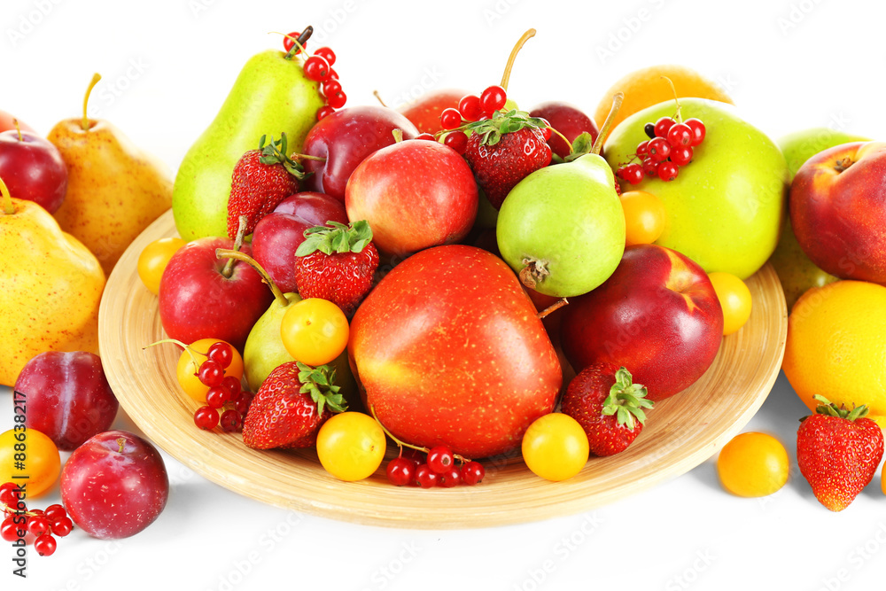 Heap of fresh fruits and berries on plate close up