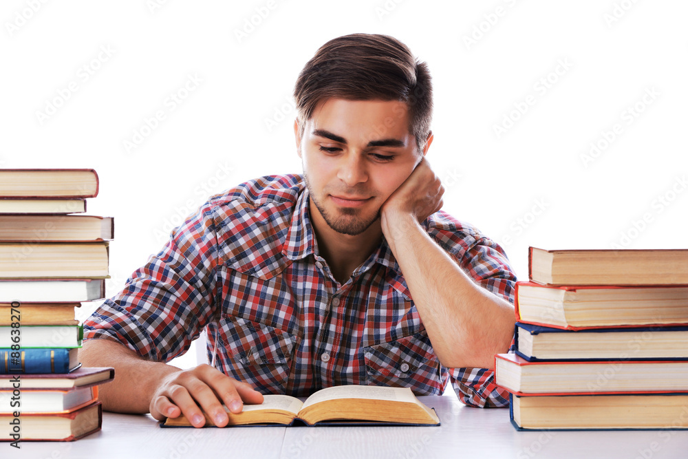 Young man reading book at table on white background Young man reading book at table on white background