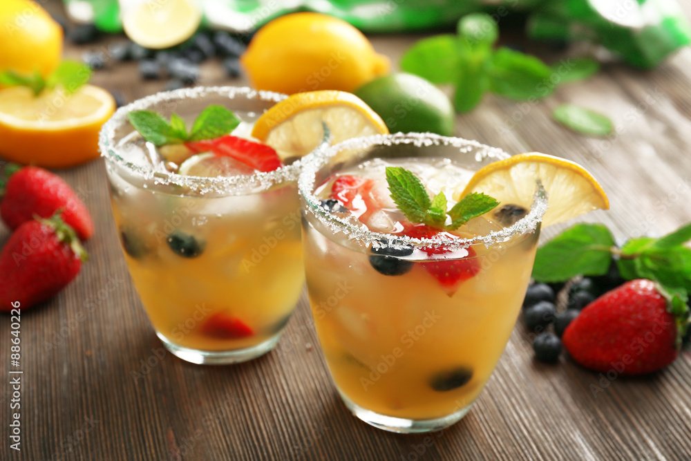 Glasses of berries juice with lemon on wooden table, closeup Glasses of berries juice with lemon on wooden table, closeup