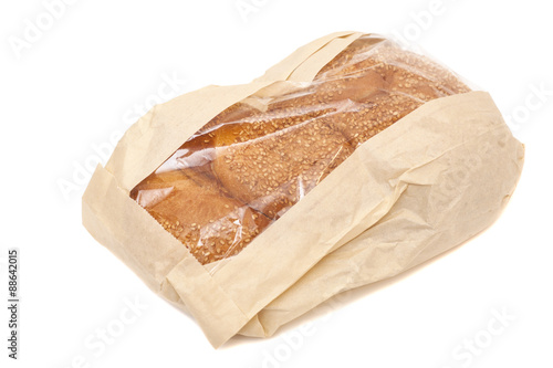 White bread with sesame in a paper bag isolated on white backgro