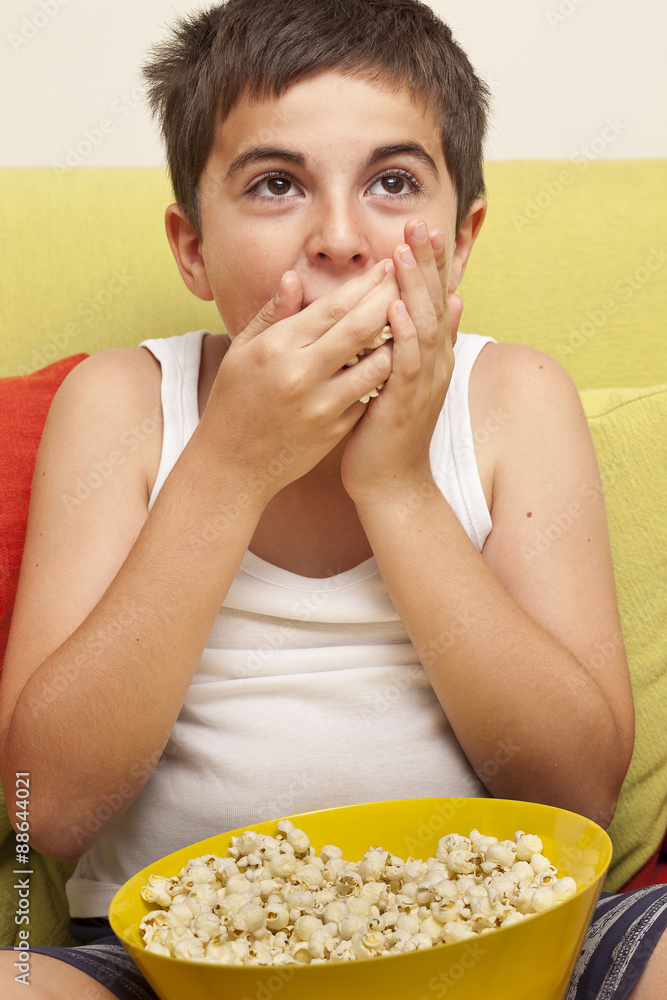 little boy sitting on a couch watching TV little boy sitting on a couch watching TV