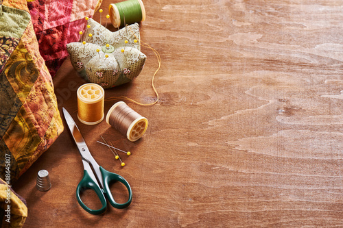 Accessories for patchwork on a quilt on a wood background