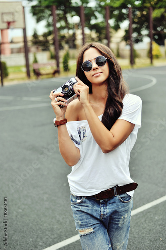 Beautiful young woman posing with old fashion camera © paultarasenko