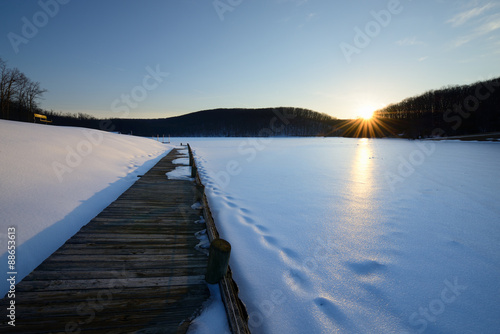 Fototapeta Naklejka Na Ścianę i Meble -  Dock and Frozen Lake at Sunset