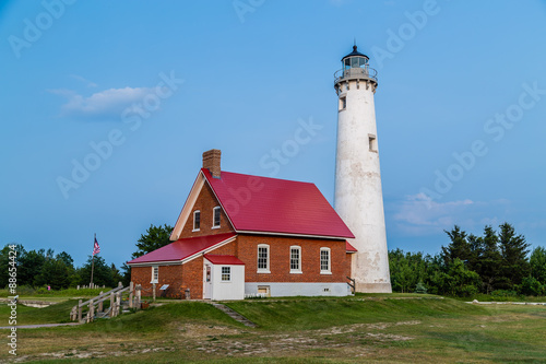 Tawas point lighthouse in the evening against blue sky