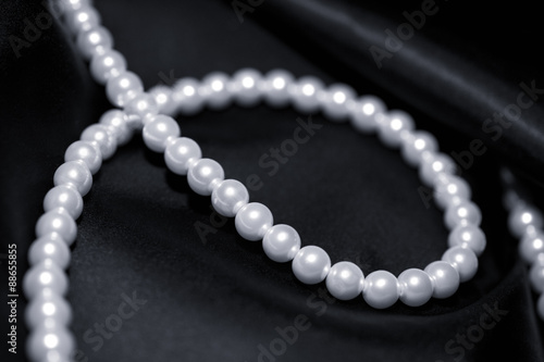 A pearl necklace on black silk macro