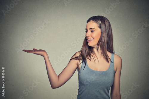 Attractive woman presenting copy space isolated on gray wall background