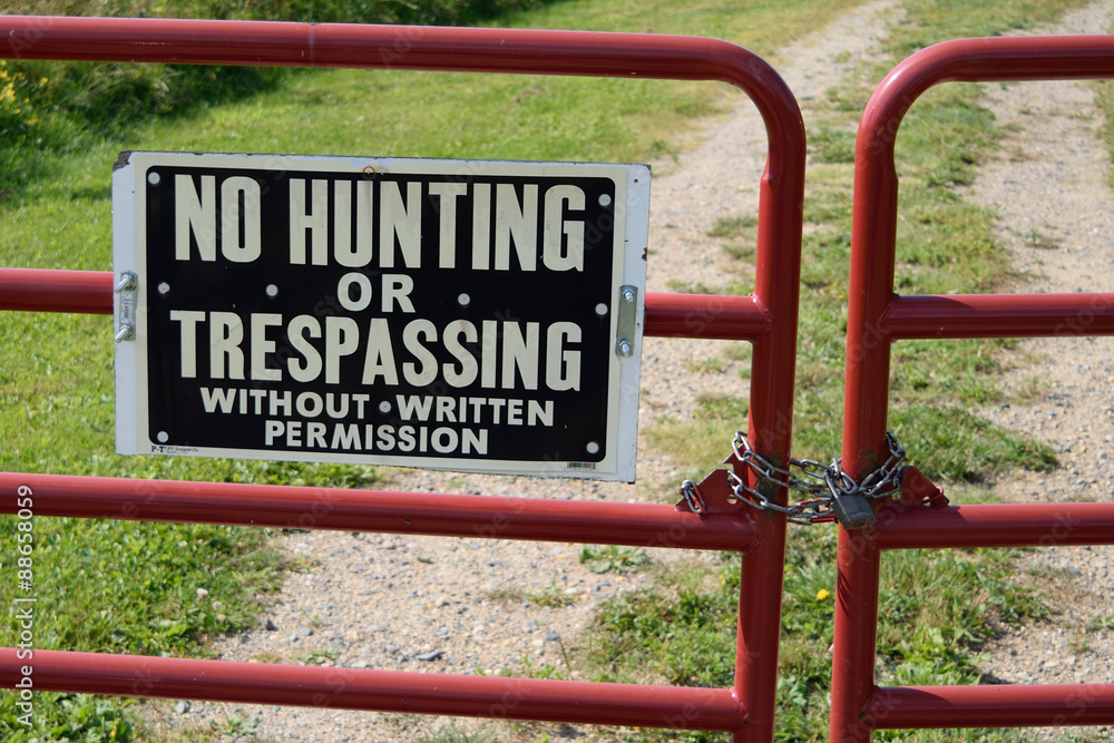 No Hunting or Trespassing Sign on Locked Gate No Hunting or Trespassing Sign on Locked Gate