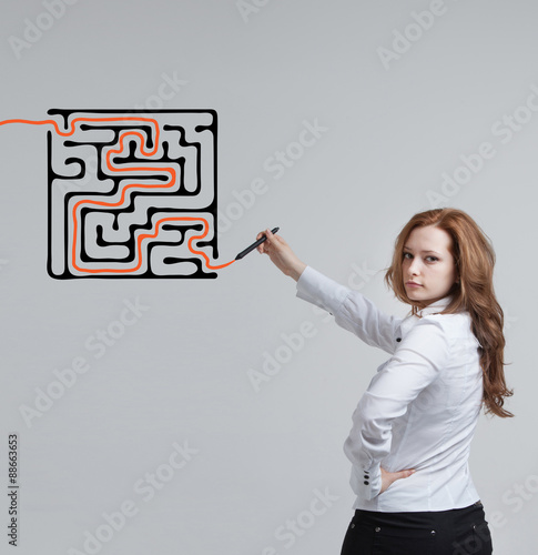 Businesswoman finding the maze solution writing on whiteboard.