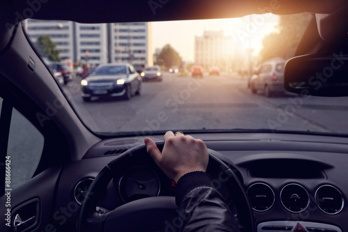 Fototapeta Naklejka Na Ścianę i Meble -  The driver goes a sunny streets in the city