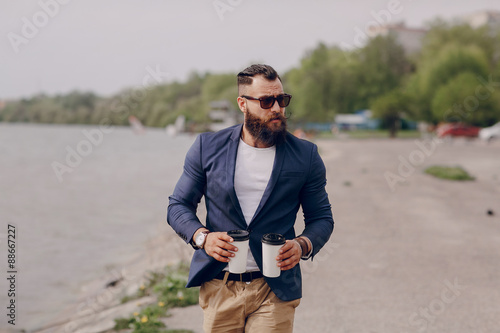 bearded man carrying coffee
