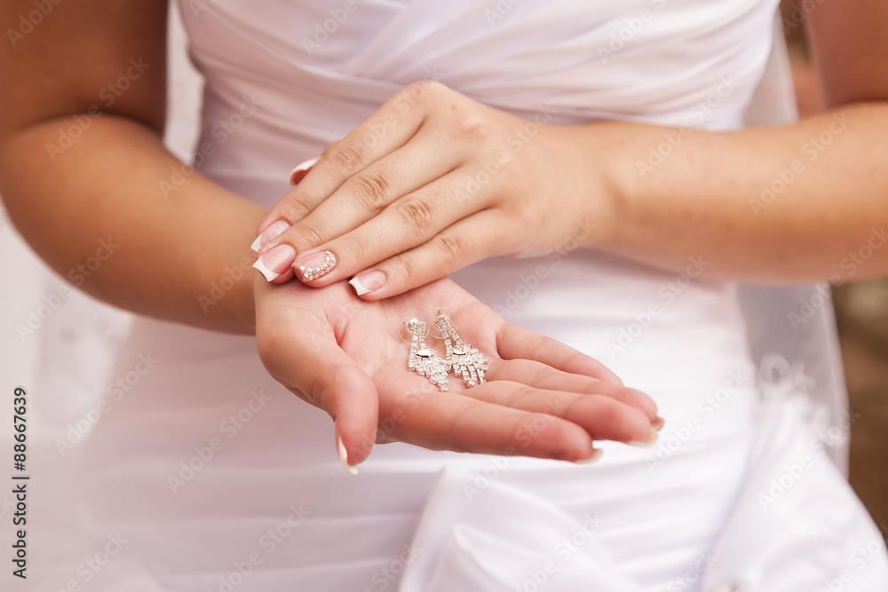 Bride holding earrings