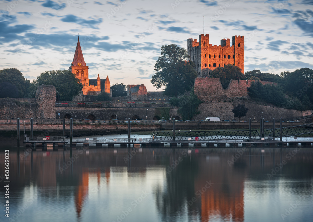 Final Ray. Rochester, United Kingdom - August 5, 2015: Final sunset ray highlights Rochester castle and cathedral. High visible evening sky and reflection on river surface.