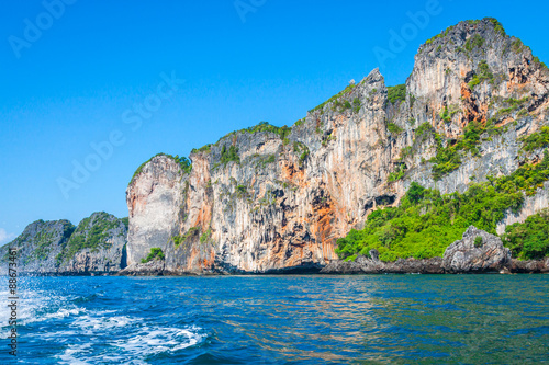 Cliff and the clear sea with a boat near Phi Phi island in south
