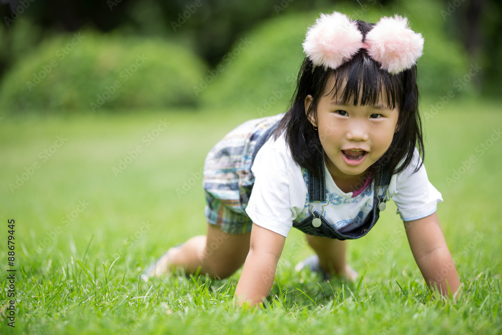Little asian girl playing on green grass at the park Little asian girl playing on green grass at the park