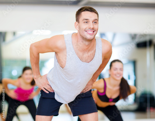 smiling male trainer working out in the gym