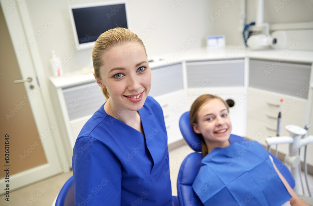 happy female dentist with patient girl at clinic happy female dentist with patient girl at clinic