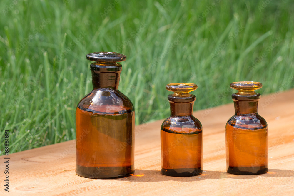 little brown bottles on booden board and grass