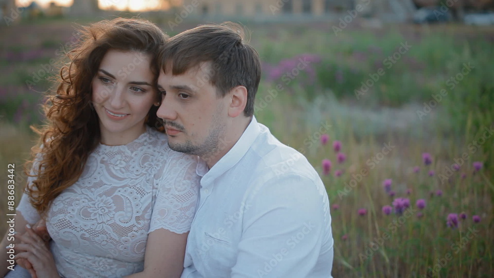 Young couple sit in the field Young couple sit in the field