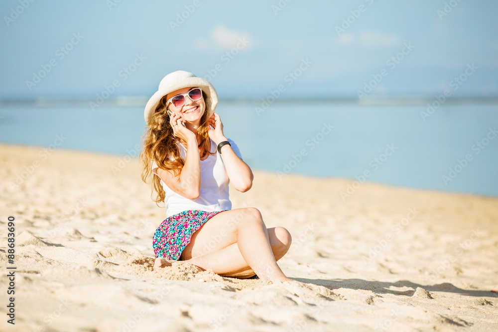Beautiful young woman at the beach talking on mobile phone and Beautiful young woman at the beach talking on mobile phone and