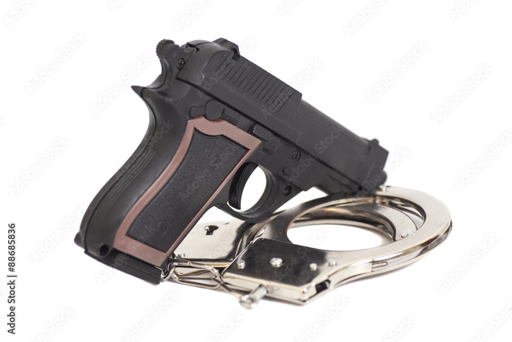 Obraz premium Gun and handcuffs isolated on white background