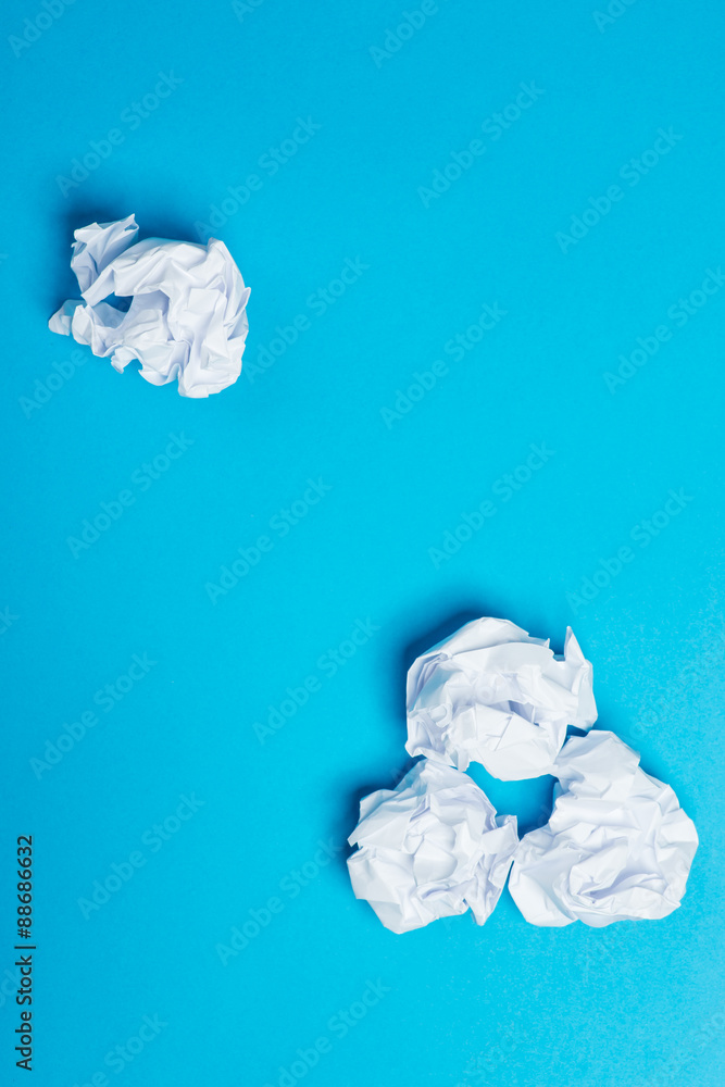 White color crumpled paper balls over the blue background White color crumpled paper balls over the blue background