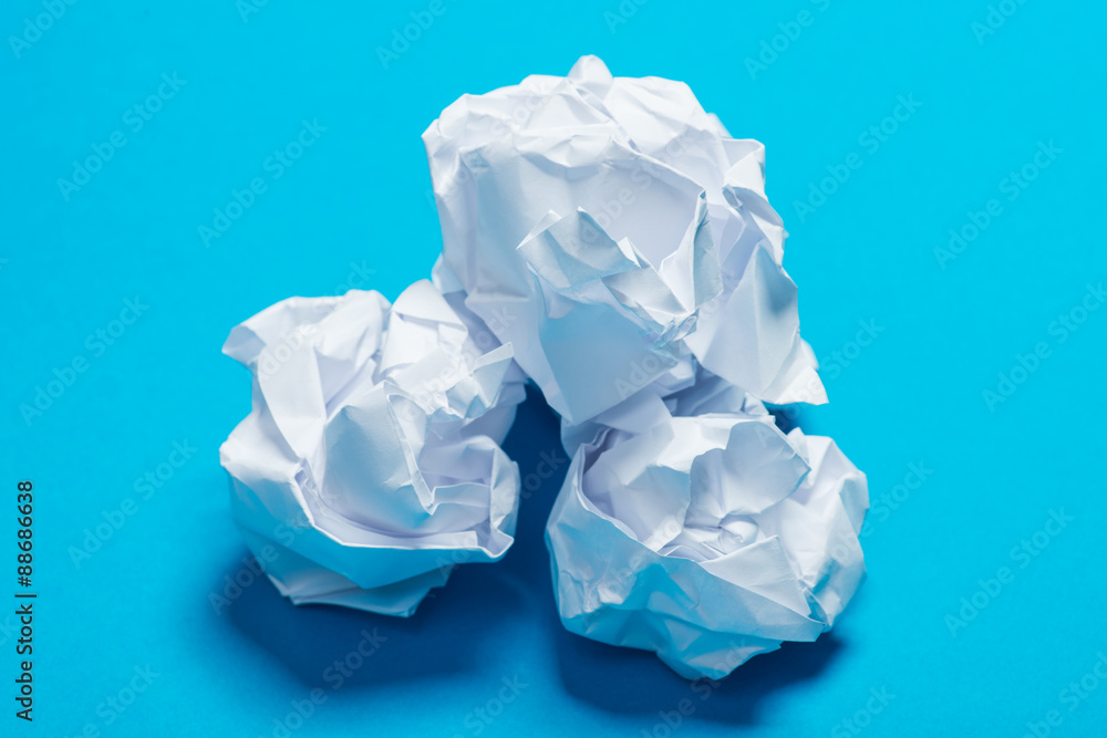 White color crumpled paper balls over the blue background White color crumpled paper balls over the blue background