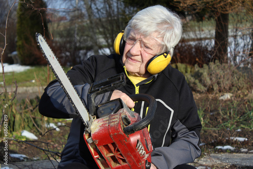 Senior woman with chainsaw