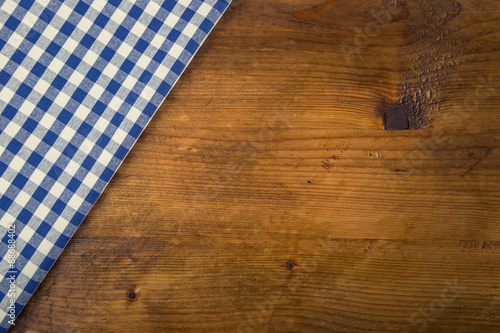 Top view of checkered napkin on wooden table. Free space for your creative information 