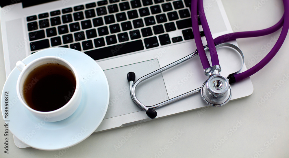 Medical stethoscope rests on top of a computer keyboard Medical stethoscope rests on top of a computer keyboard