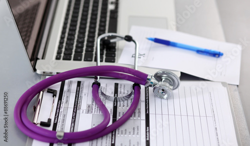 Medical stethoscope rests on top of a computer keyboard