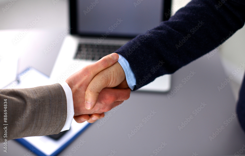 Business people handshake, sitting at the table