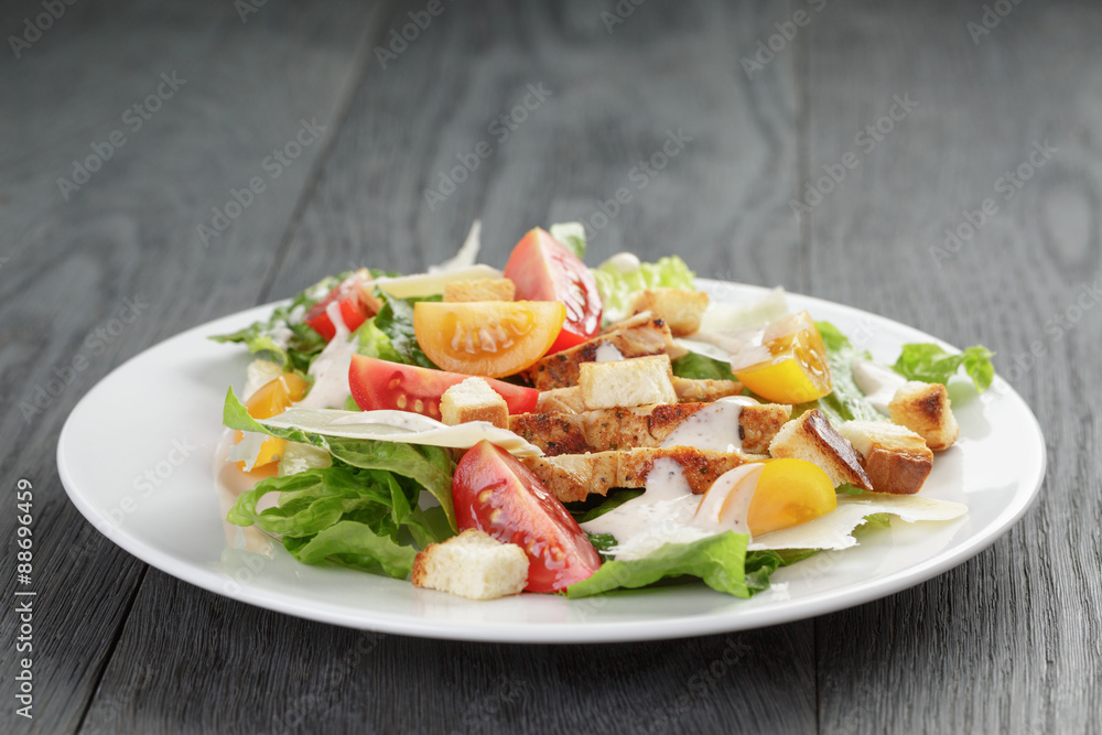 caesar salad with chicken on oak table caesar salad with chicken on oak table