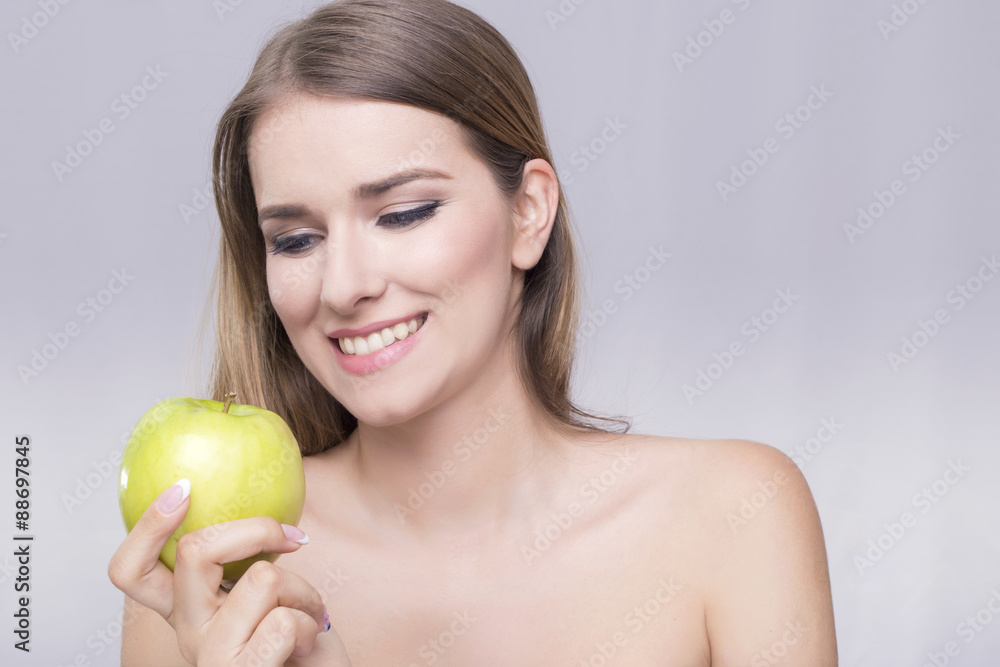 Blonde woman smiling at the apple Blonde woman smiling at the apple