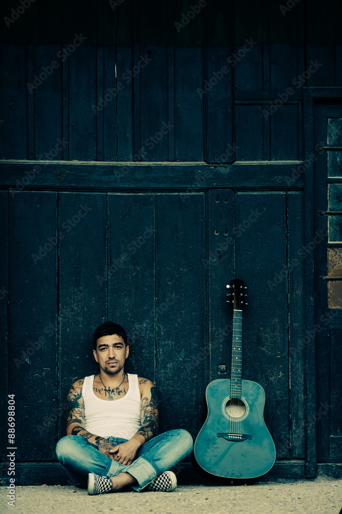 Fototapeta Hipster male with tattoes with guitar