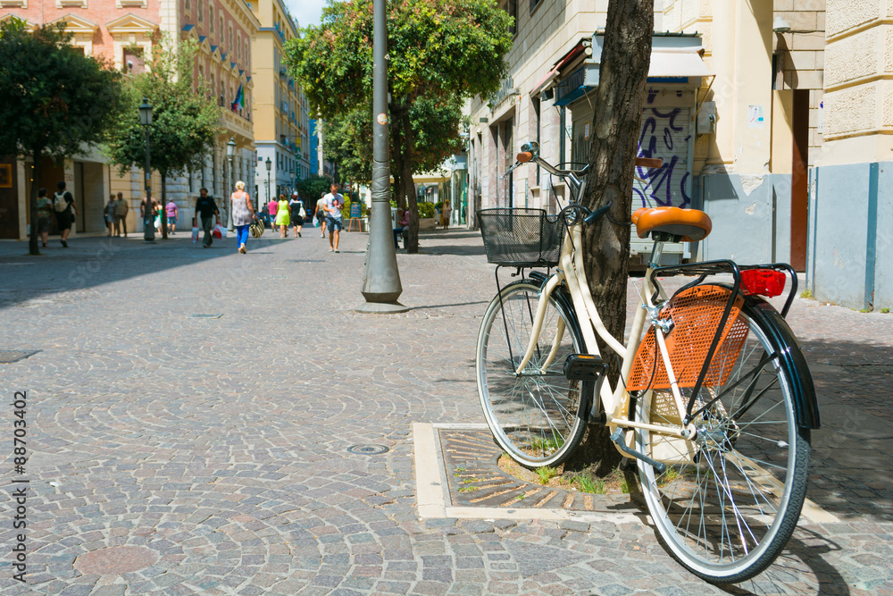 Elegant bicycle parked against a tree on the central street of the town of Salerno, southern Italy.
