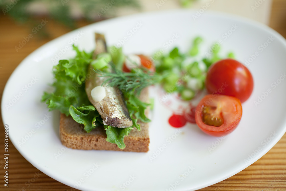 sprats, bread and tomatoes on a saucer