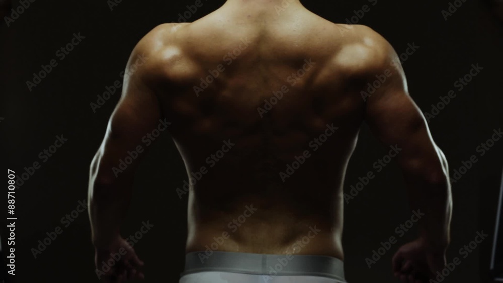 Young man showing work of muscles of body - spine Young man showing work of muscles of body - spine