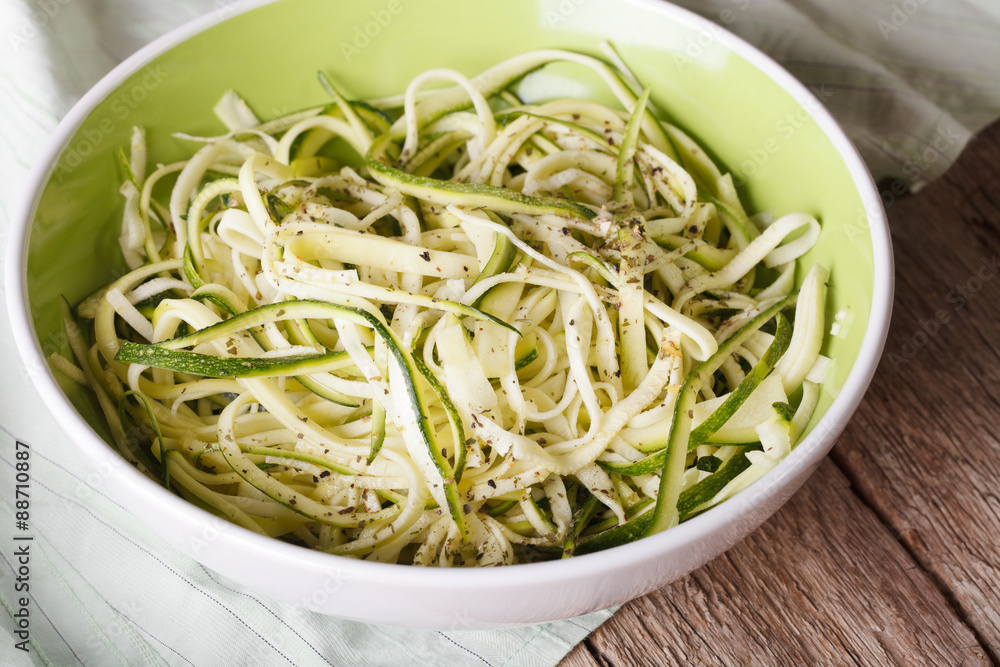 Natural food: raw zucchini pasta in a bowl closeup. horizontal
Natural food: raw zucchini pasta in a bowl closeup. horizontal